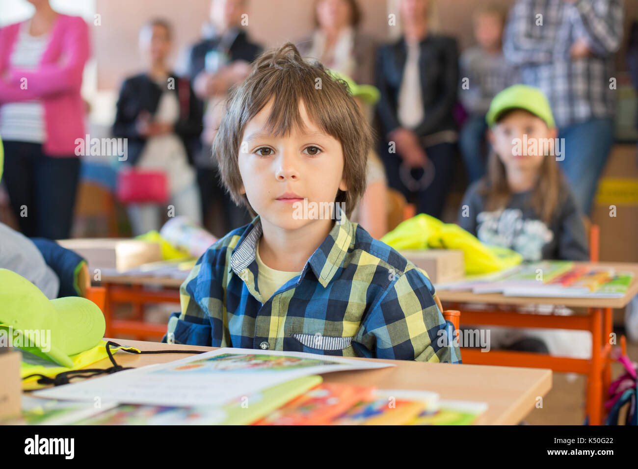 Young first grade student sitting at desk on his first day at school in the classroom Stock Photo