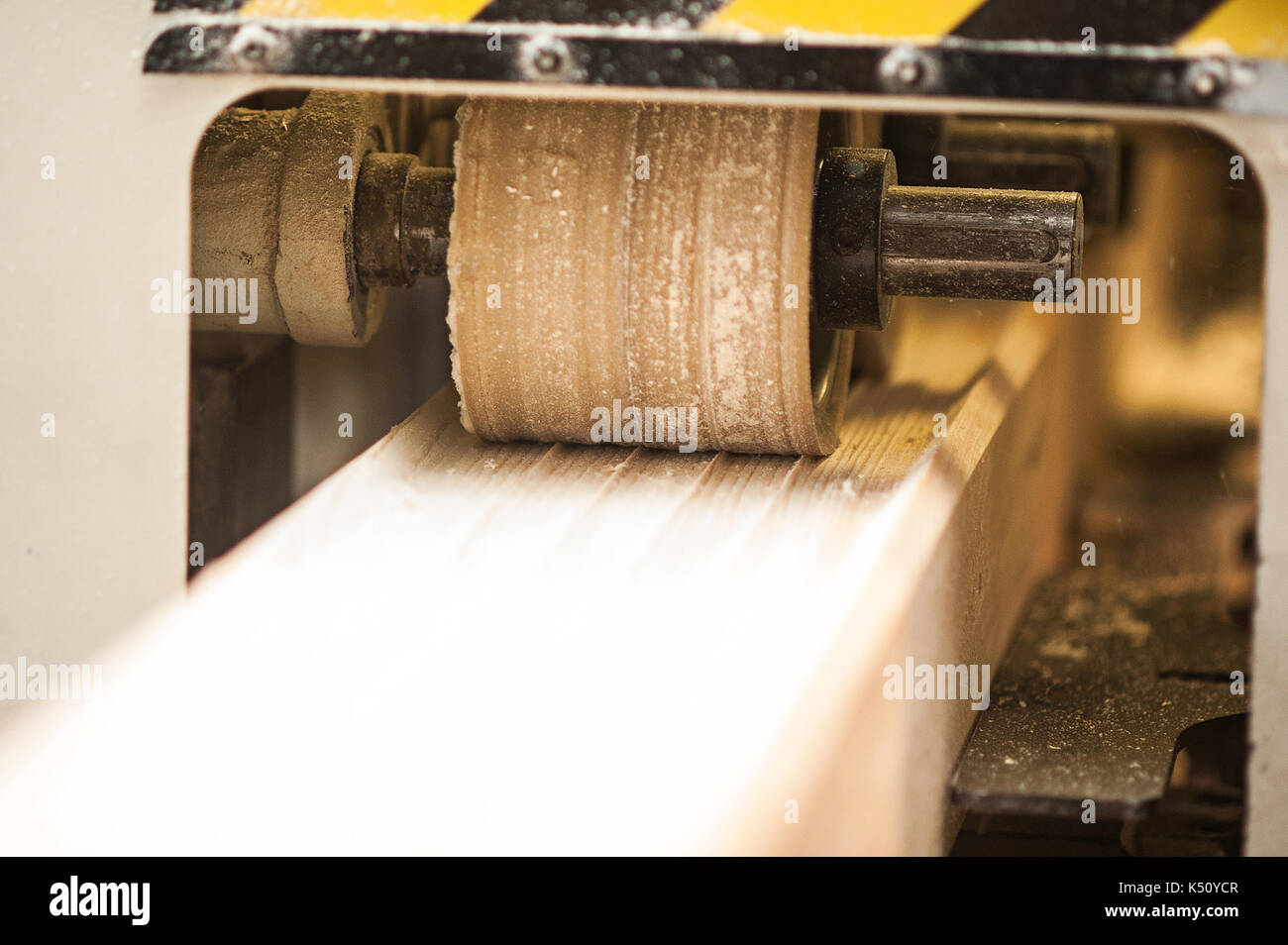 Woodworking machine with plane during processing. Machine tool in factory. Stock Photo