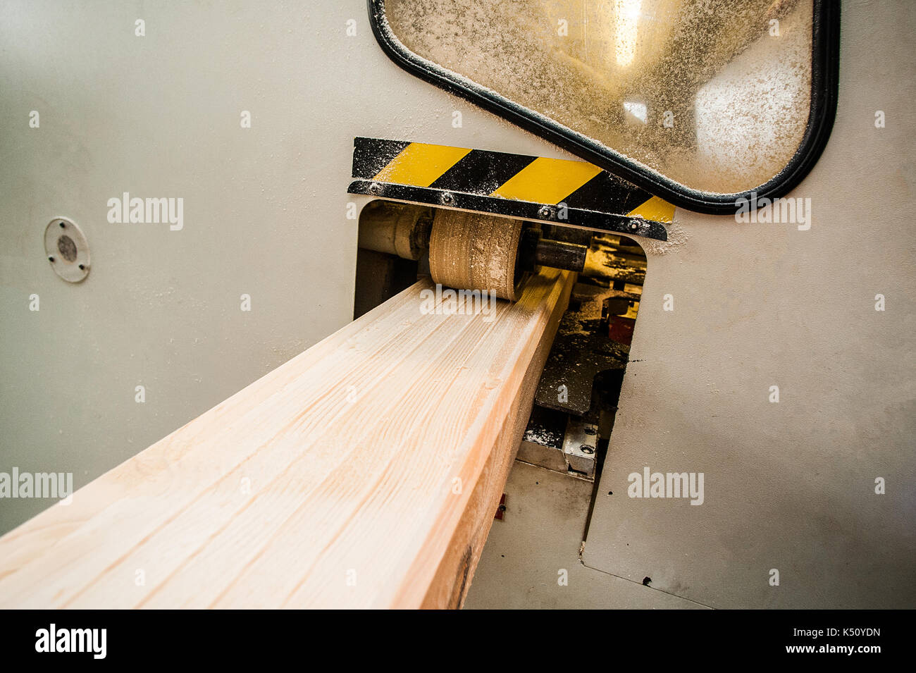 Woodworking machine with plane during processing. Machine tool in factory. From afar Stock Photo
