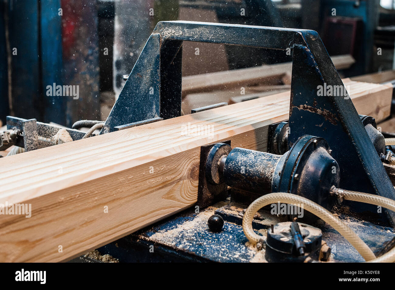 Circular Saw. Carpenter Using Circular Saw for wood. Woodworking machine sawing wooden beam Stock Photo