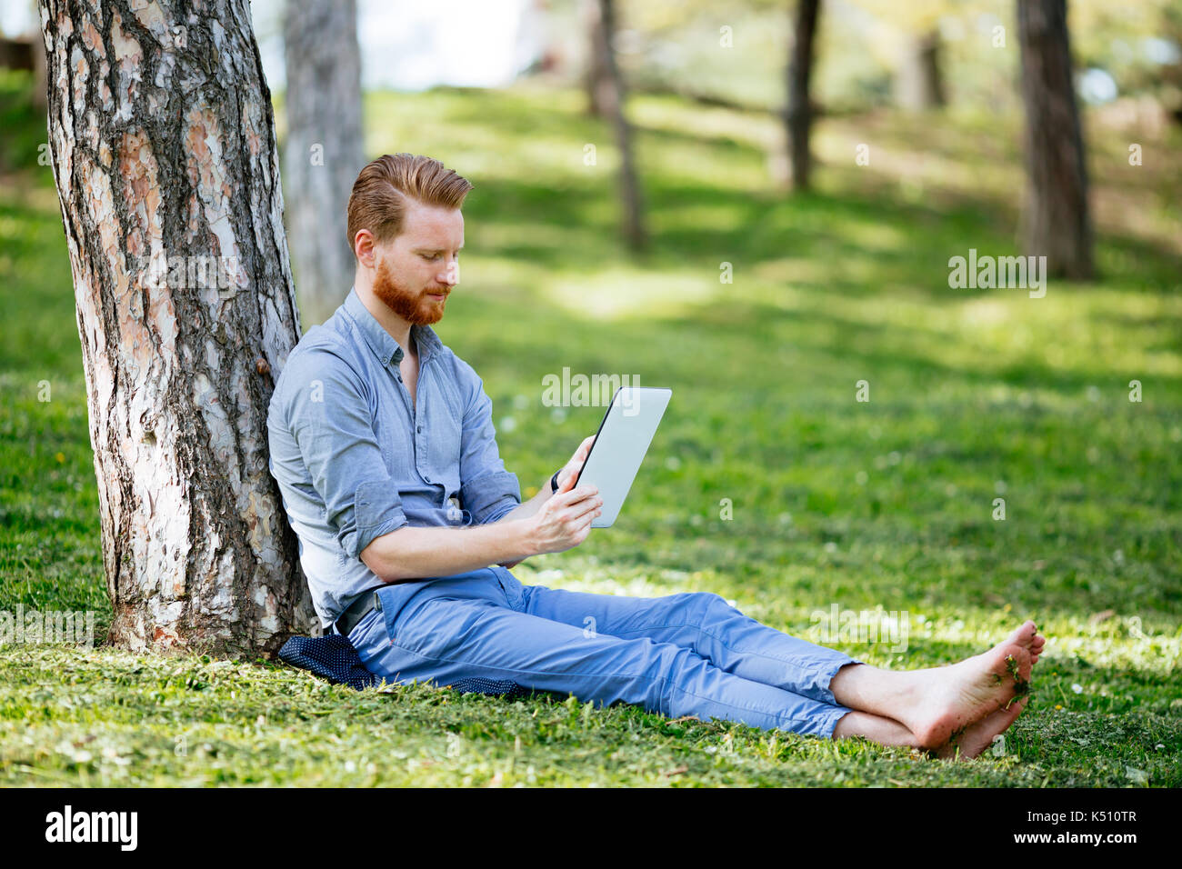 Businessman using tablet in park Stock Photo