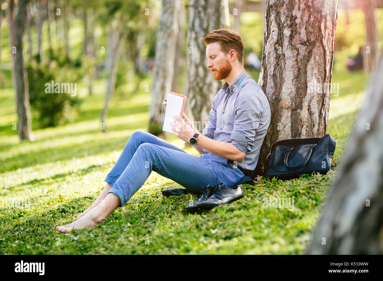 Handsome student reading in nature Stock Photo