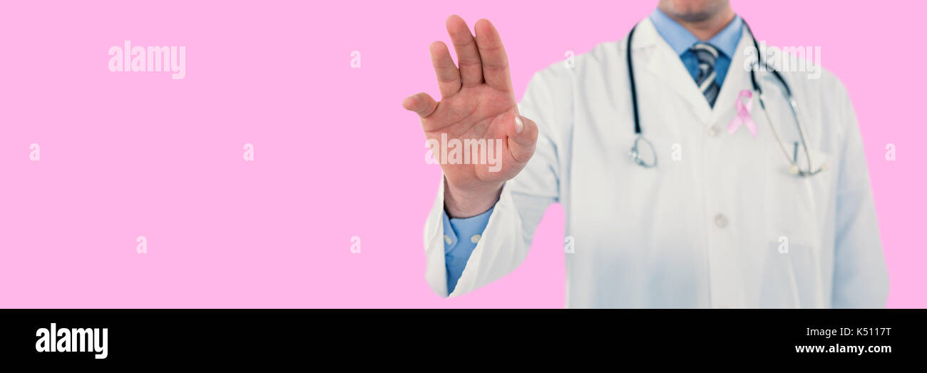 Doctor touching an digital screen  against pink background Stock Photo