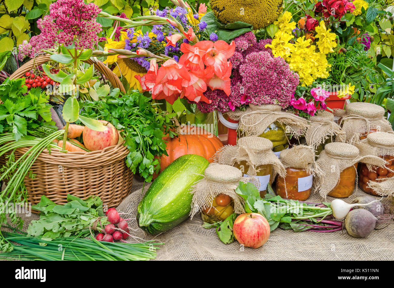 Apples, radish, carrots, pickled vegetables, pumpkins and a variety of different kind of flowers presented at the harvest festival Stock Photo