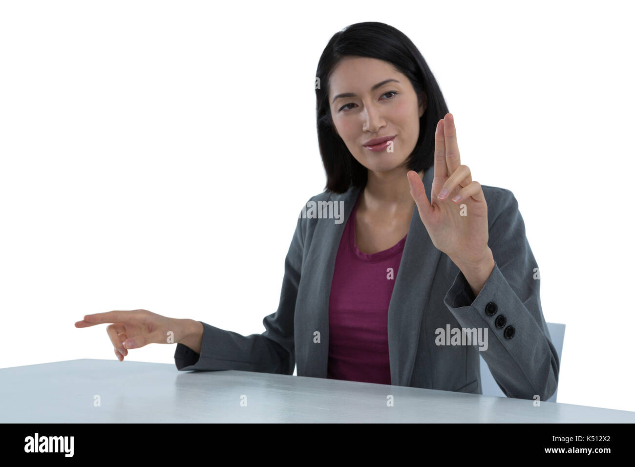 Businesswoman touching invisible screen against white background Stock Photo