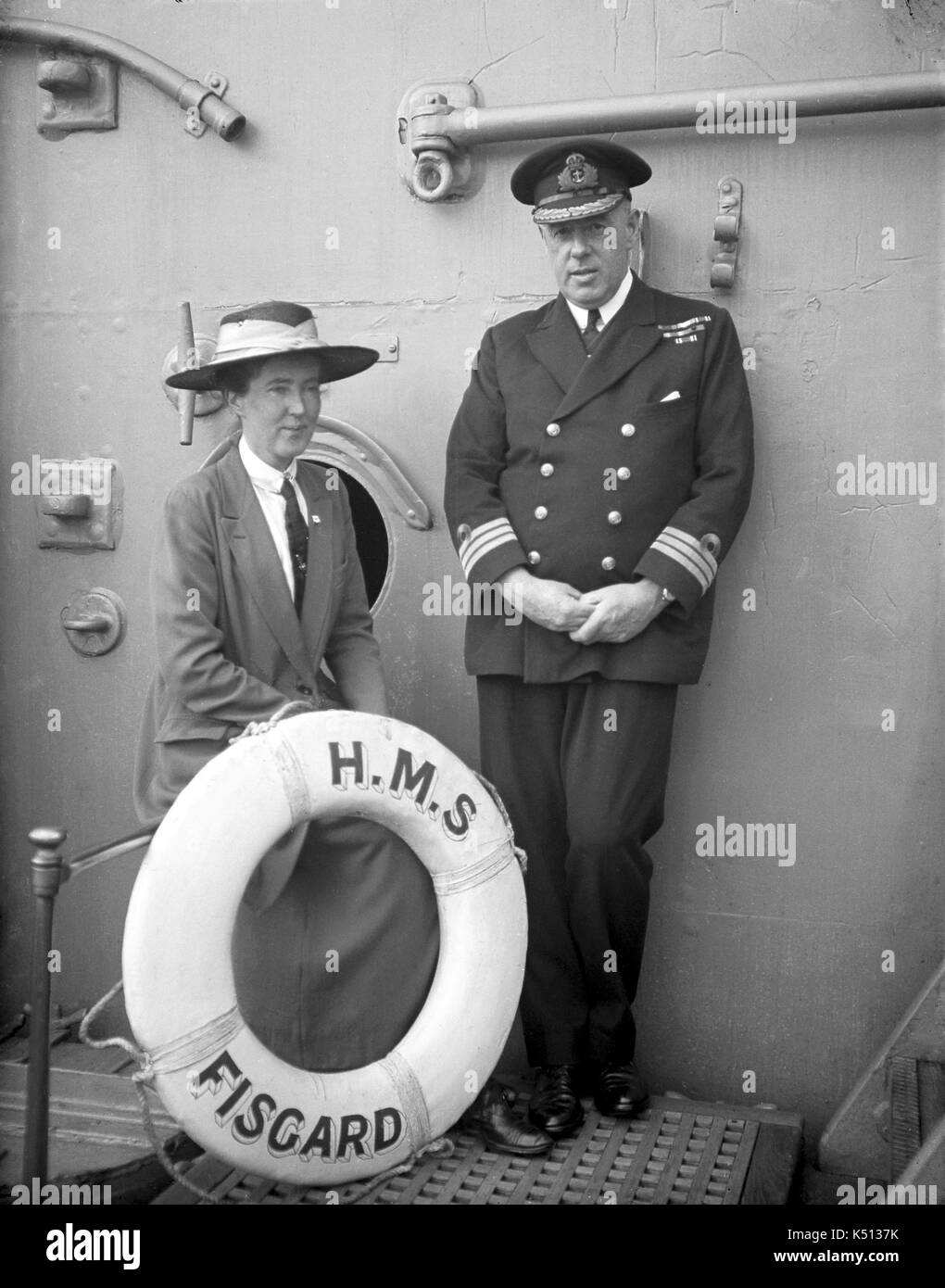 AJAXNETPHOTO. 1915 - 1932 (APPROX). LOCATION UNKNOWN. - HMS FISGARD PORTRAIT - A ROYAL NAVAL OFFICER AND A LADY IN A HAT POSE WITH THE SHIP'S LIFEBUOY. THE SHIP IS POSSIBLY THE DIADEM CLASS PROTECTED CRUISER HMS SPARTIATE RENAMED FISGARD IN 1915.  PHOTOGRAPHER:UNKNOWN © DIGITAL IMAGE COPYRIGHT AJAX VINTAGE PICTURE LIBRARY SOURCE: AJAX VINTAGE PICTURE LIBRARY COLLECTION REF:()AVL PEO HMS FISCARD 1902 01 Stock Photo