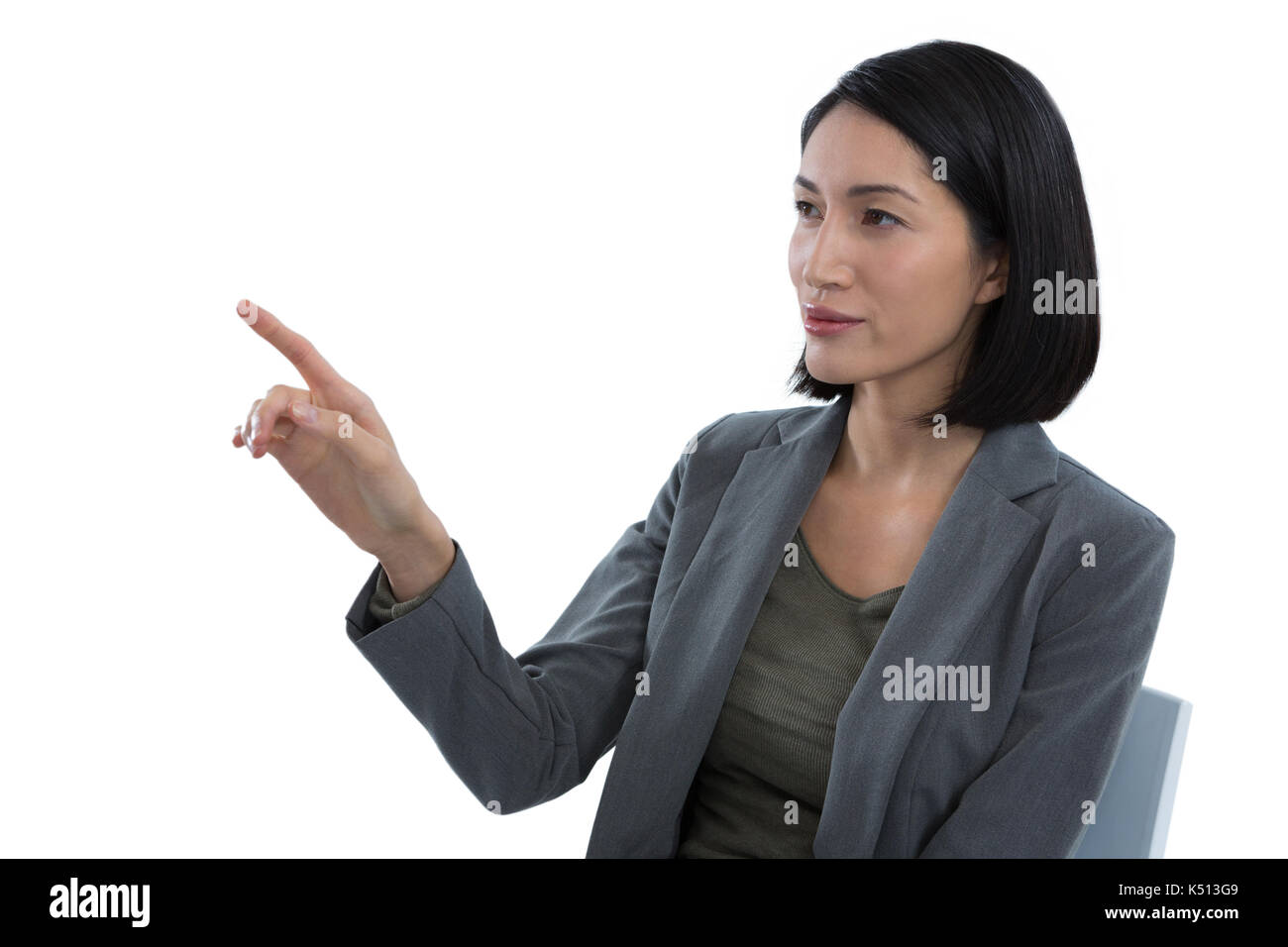 Businesswoman touching invisible screen against white background Stock Photo