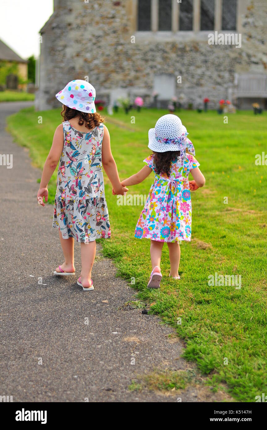 Two young girls holding hands in the summer Stock Photo - Alamy