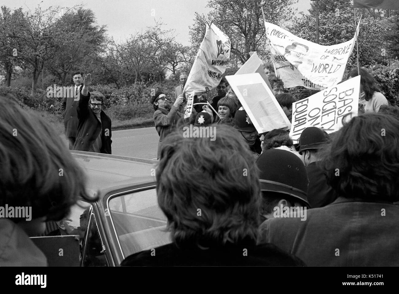 British MP Enoch Powell is confronted by anti-racism demonstrators as he arrives at a public meeting three weeks after his controversial speech on immigration that became known as the “rivers of blood” speech.  He drove to the meeting at Chippenham in Wiltshire on 11 May 1968 to find police guarding the gates as students from Bristol University picketed outside. Stock Photo