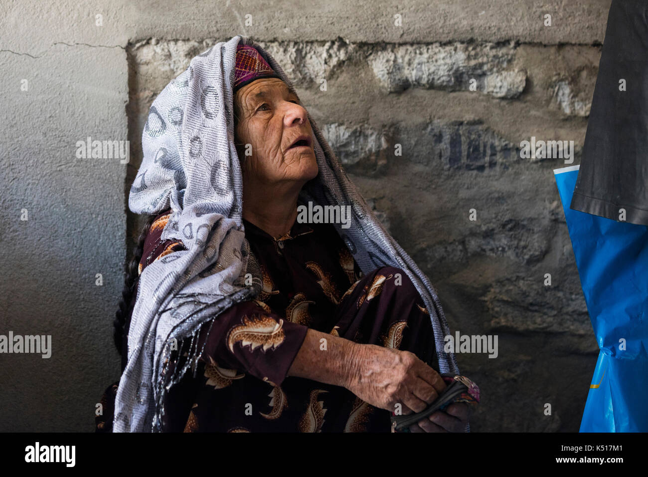Old Afghan woman in traditional dress at the Saturday Market / Tajik-Afghan friendship market in Khorugh, capital of Gorno-Badakhshan in Tajikistan Stock Photo