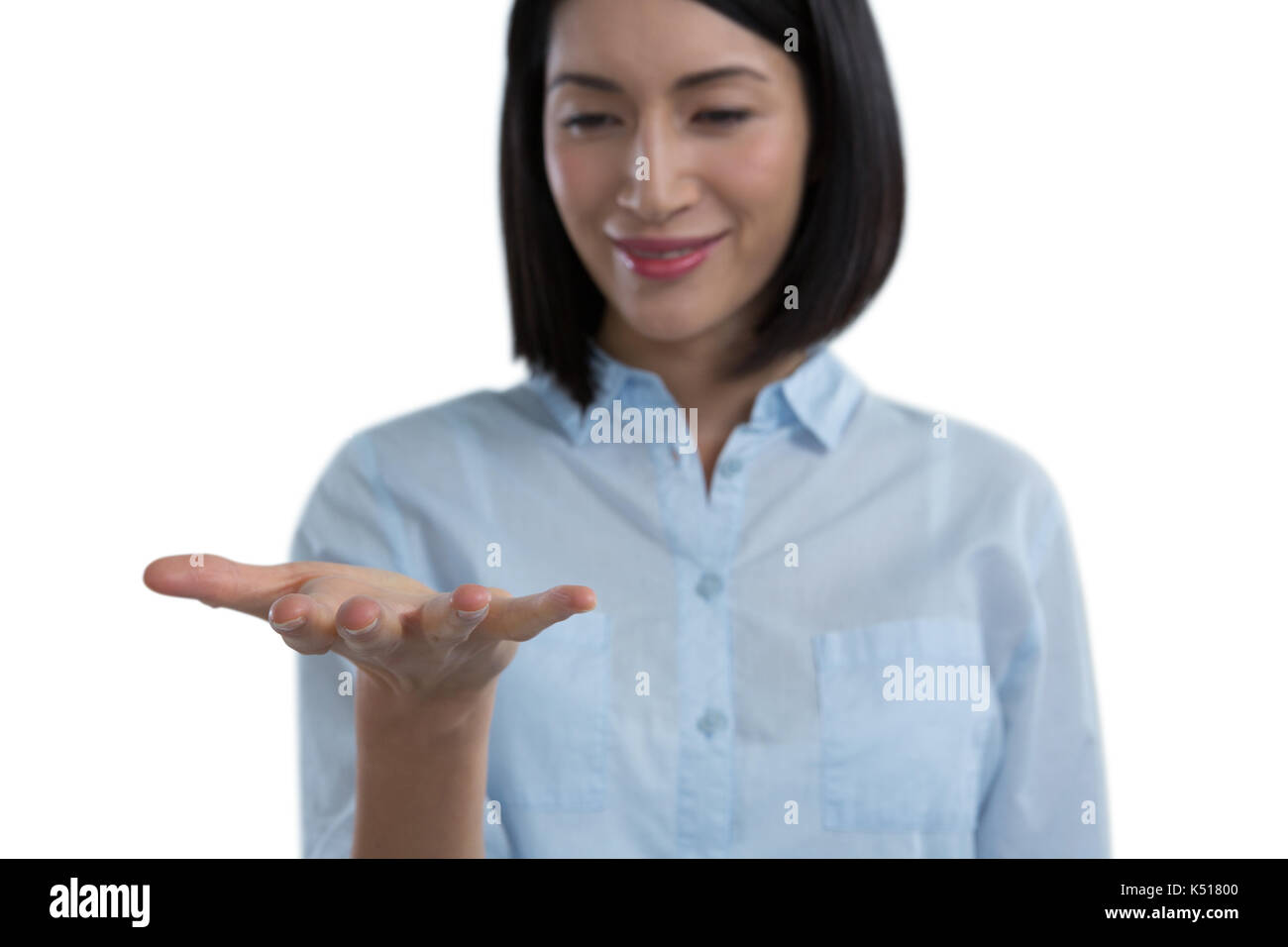 Woman pretending to hold an invisible object against white background ...