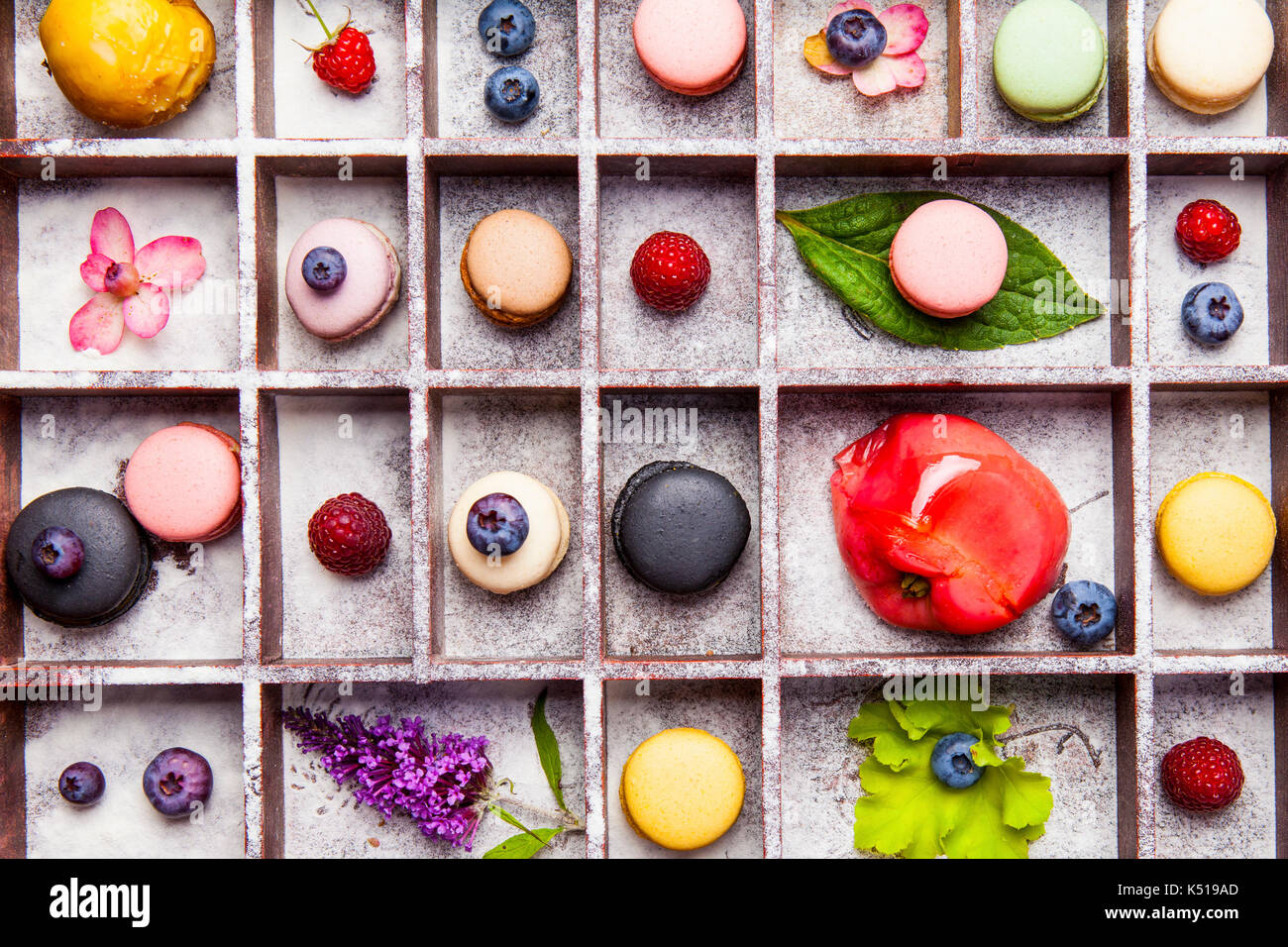 Variety of colorful french sweet dessert - makaron ( les macarons) with autumn flowers and berries. Stock Photo