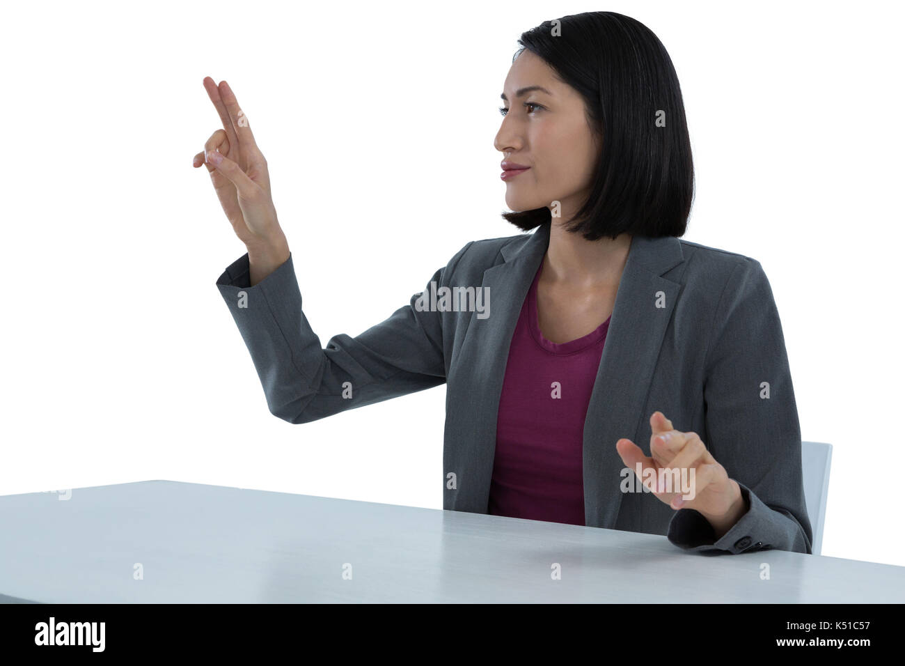 Businesswoman touching invisible screen against white background Stock Photo