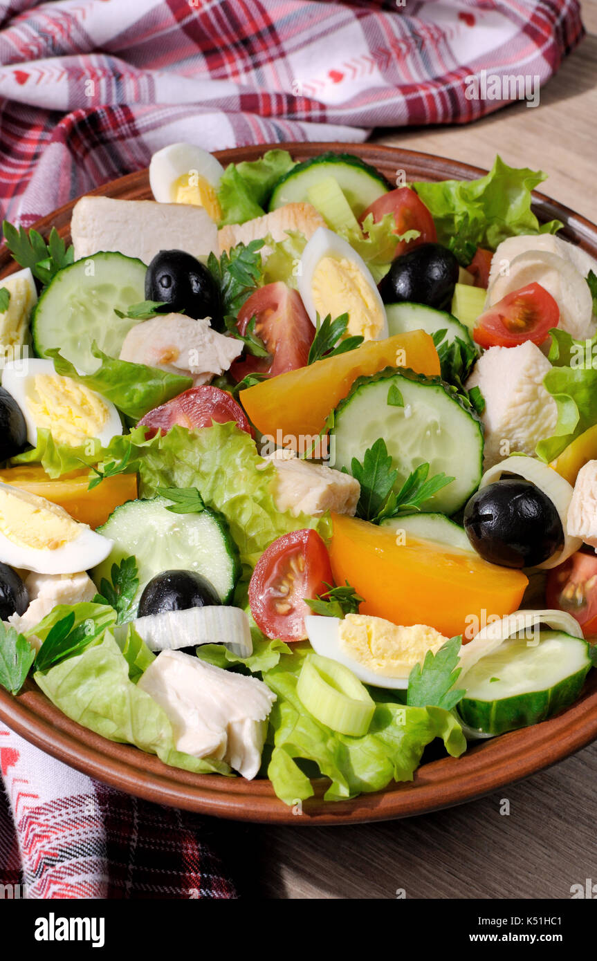 Vegetable salad with chicken and eggs, olives in lettuce leaves. Vertically  shot. Stock Photo