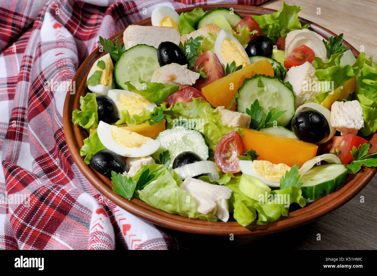 Vegetable salad with chicken and eggs, olives in lettuce leaves. Horizontal shot. Close-up. Stock Photo