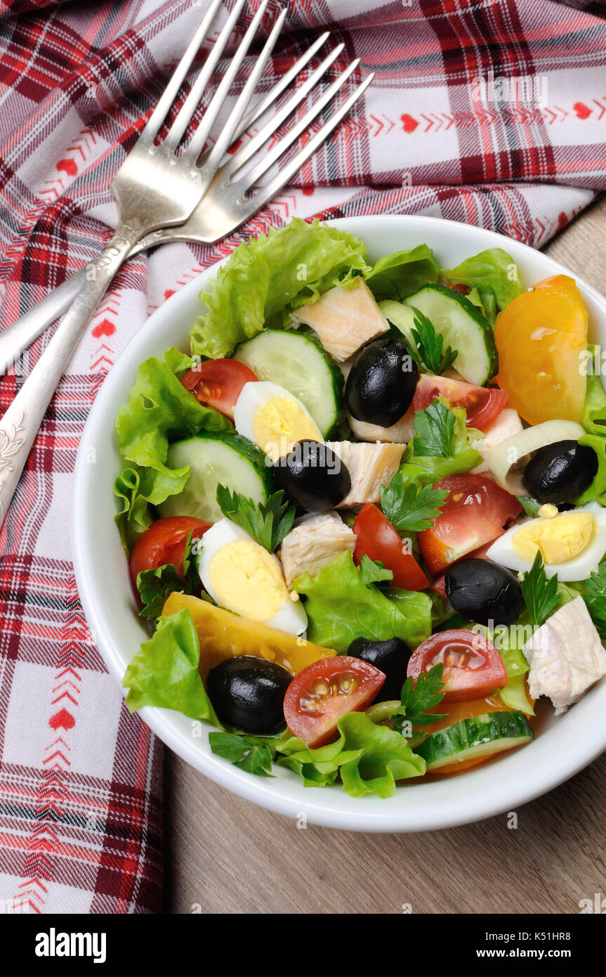 Vegetable salad with chicken and eggs, olives in lettuce leaves. Vertically  shot. Stock Photo