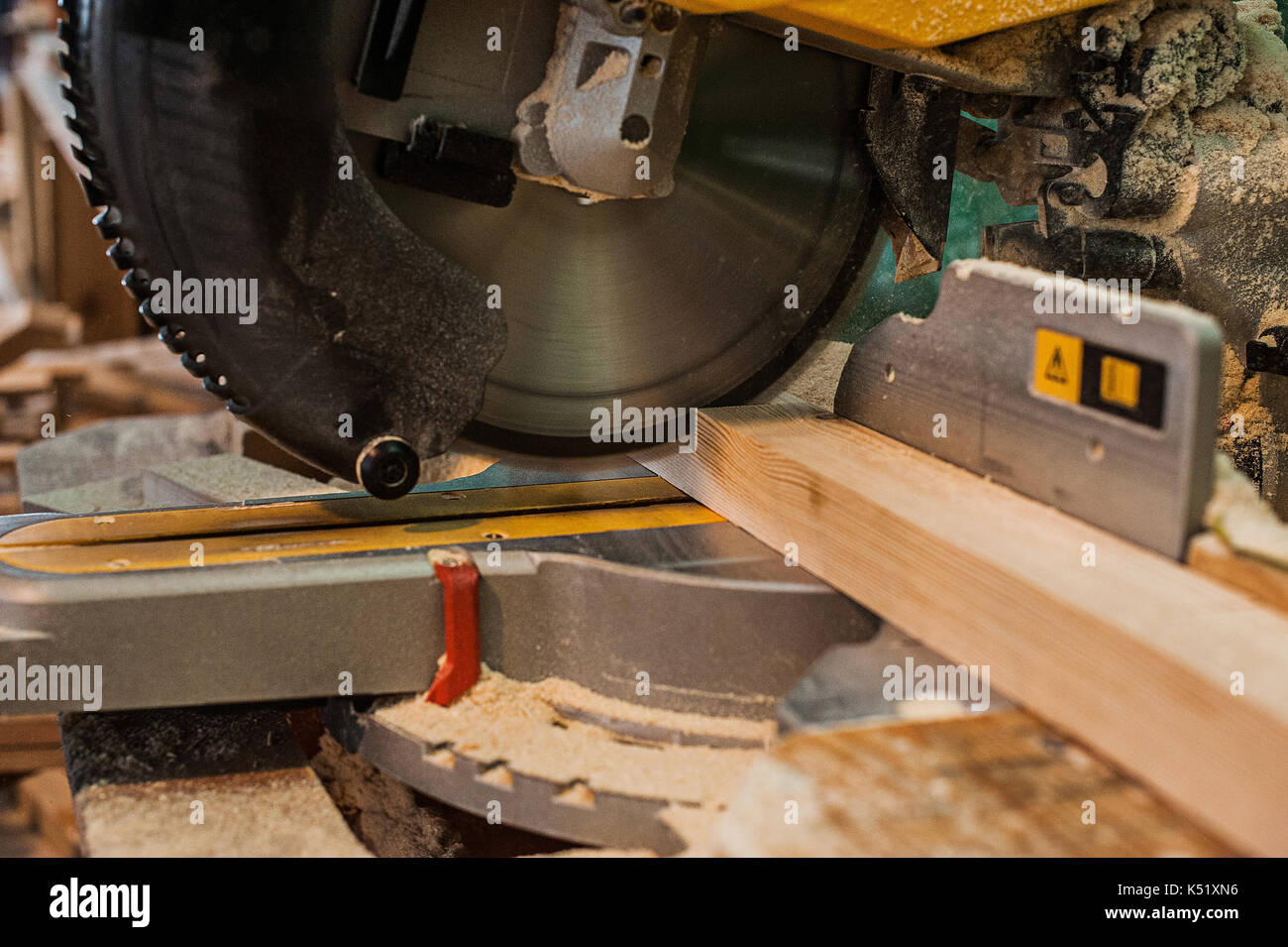 Circular saw with a wooden beam and measuring scale. Sawing a wooden beam with a circular saw. close Stock Photo