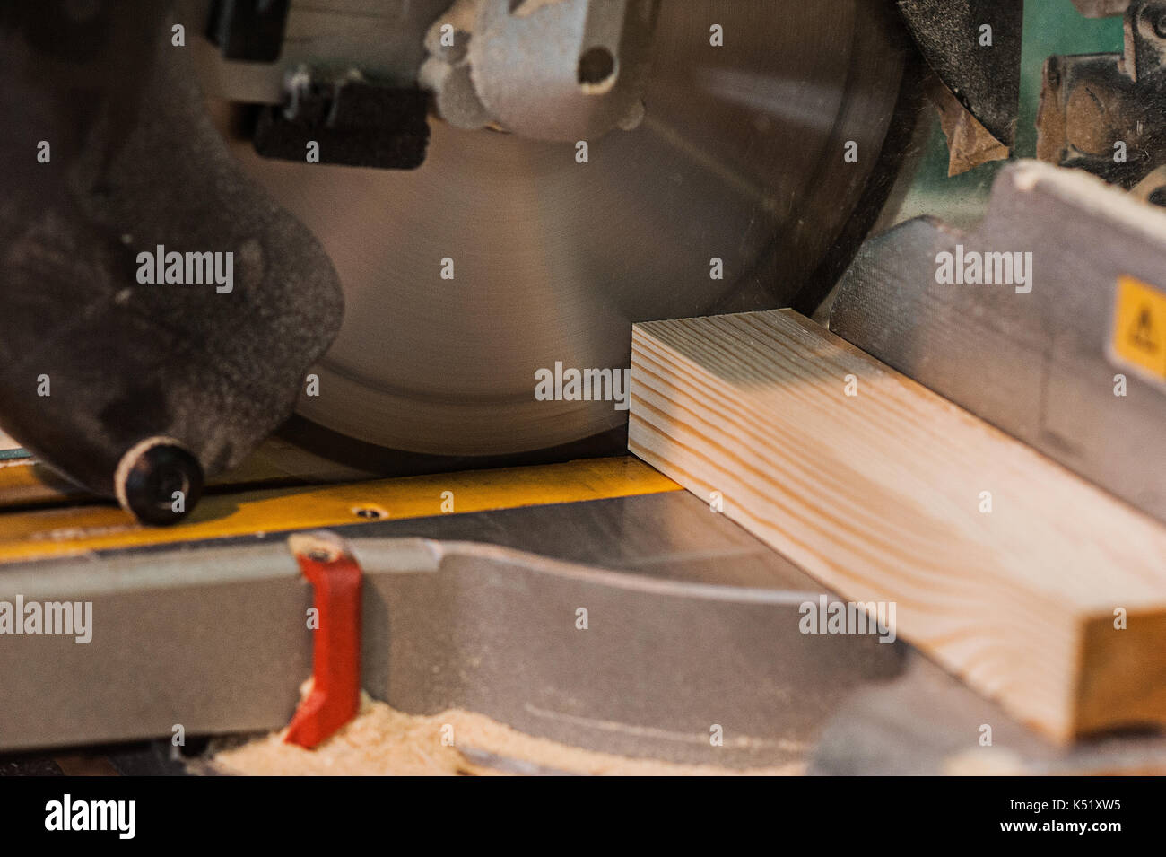 Circular saw with a wooden beam and measuring scale. Sawing a wooden beam with a circular saw. abother view close up Stock Photo
