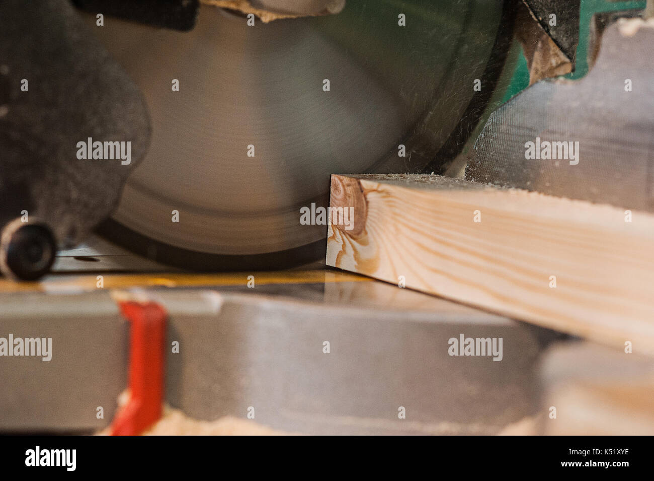 Circular saw with a wooden beam and measuring scale. Sawing a wooden beam with a circular saw. in progress view Stock Photo