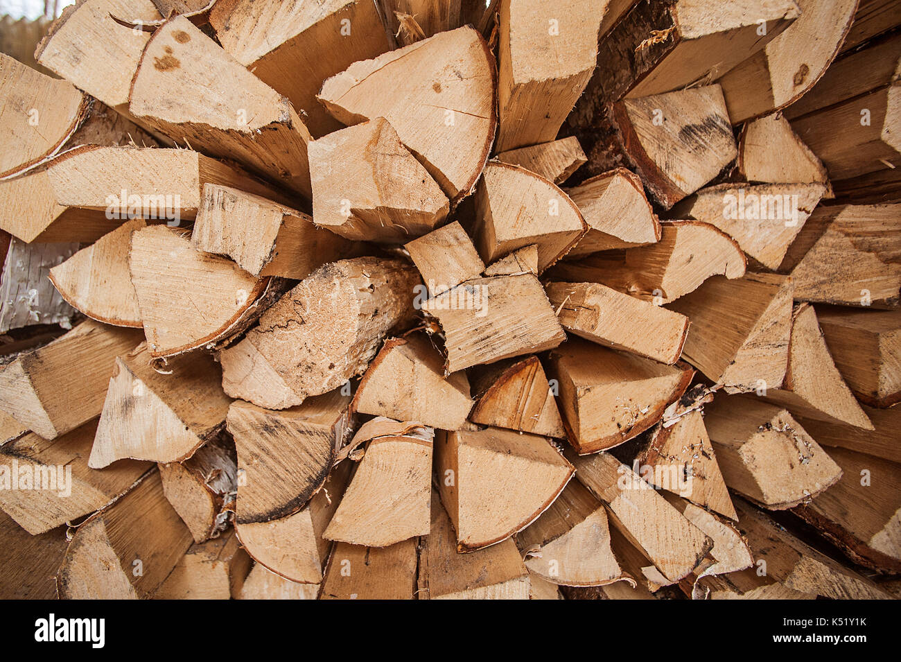 Natural wooden background, closeup of chopped firewood. Firewood stacked and prepared for winter Pile of wood logs. Chopped firewood on a stack. Stock Photo