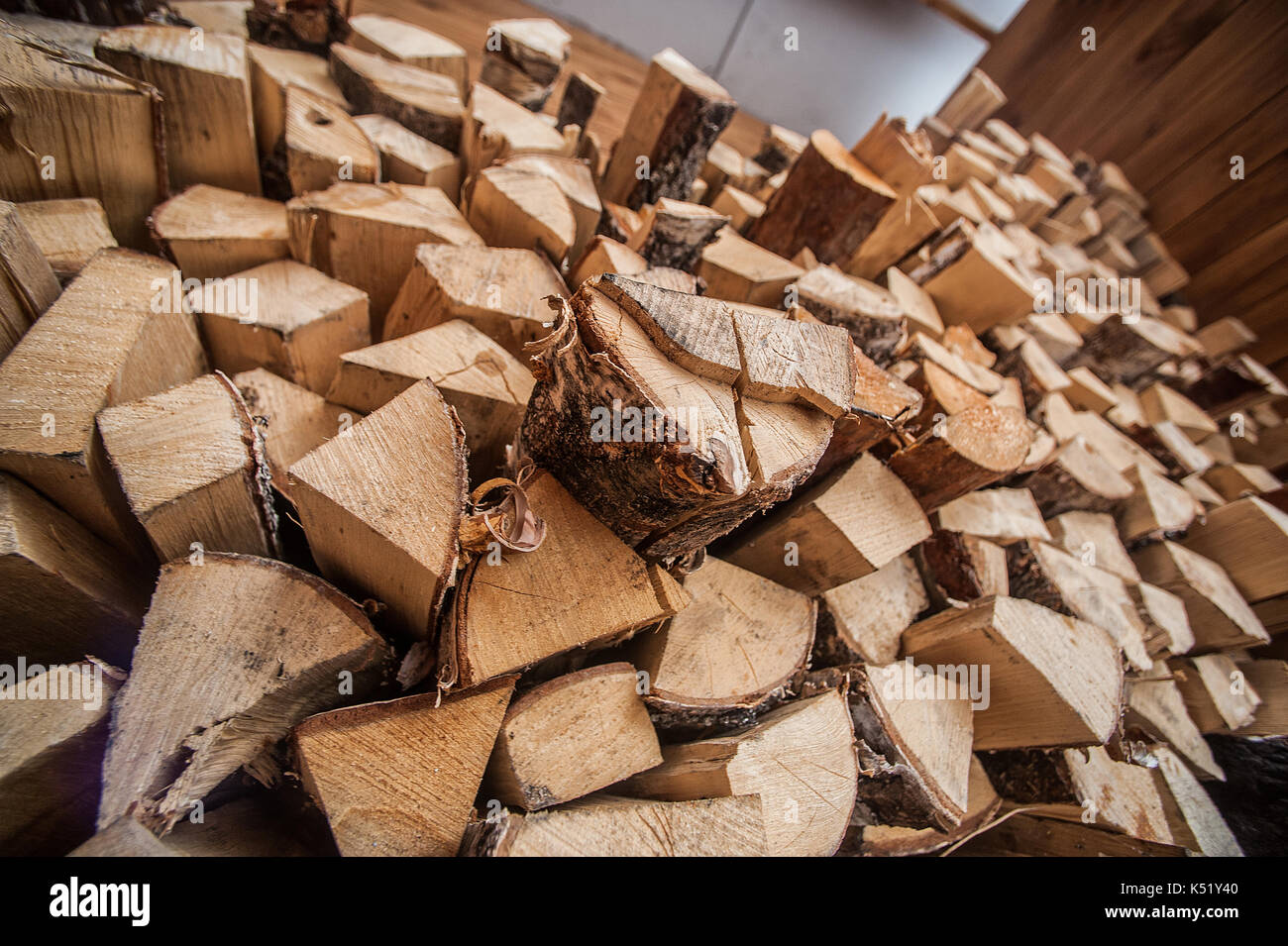 Natural wooden background, closeup of chopped firewood. Firewood stacked and prepared for winter Pile of wood logs. Chopped firewood on a stack. diffe Stock Photo