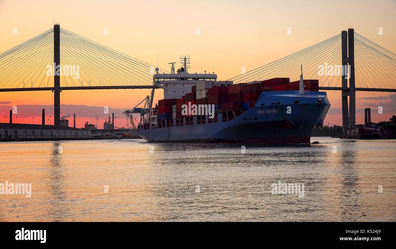 A commercial cargo ship as it leaves the Port of Savannah in Georgia at sunset Stock Photo