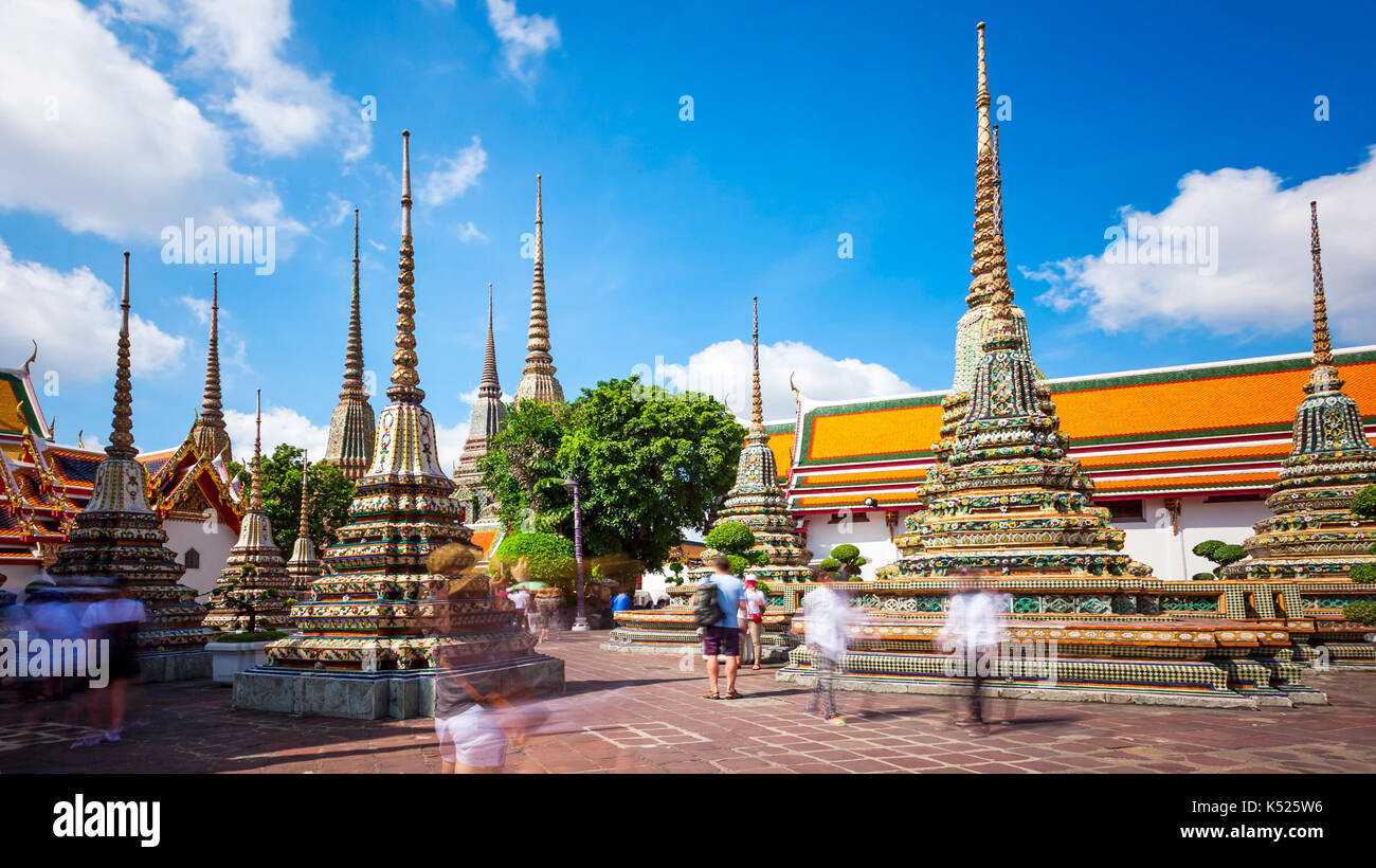 Tourists admire the many buddhist stupas at Wat Pho temple in Bangkok, Thailand (faces blurred for commercial use) Stock Photo