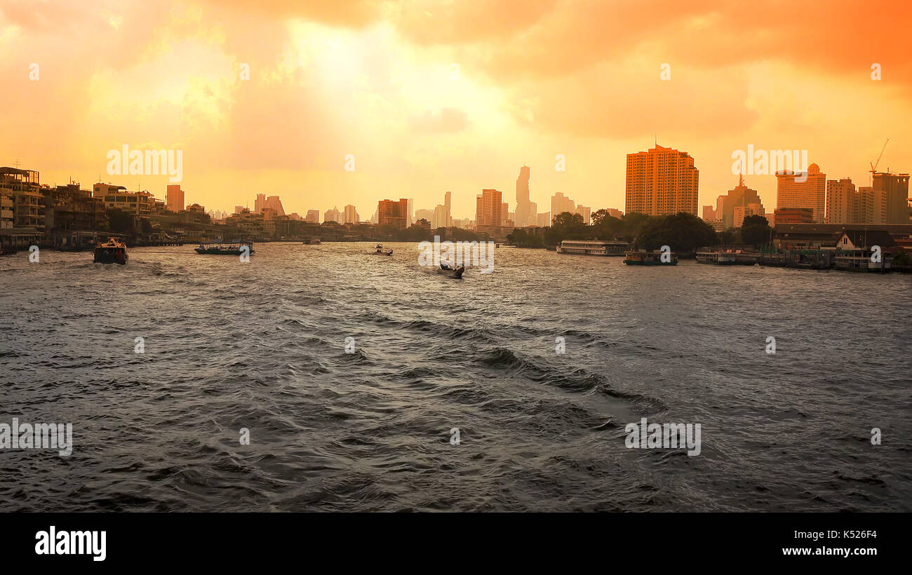 Bangkok city skyline and boats on the Chao Phraya River at sunrise in ...