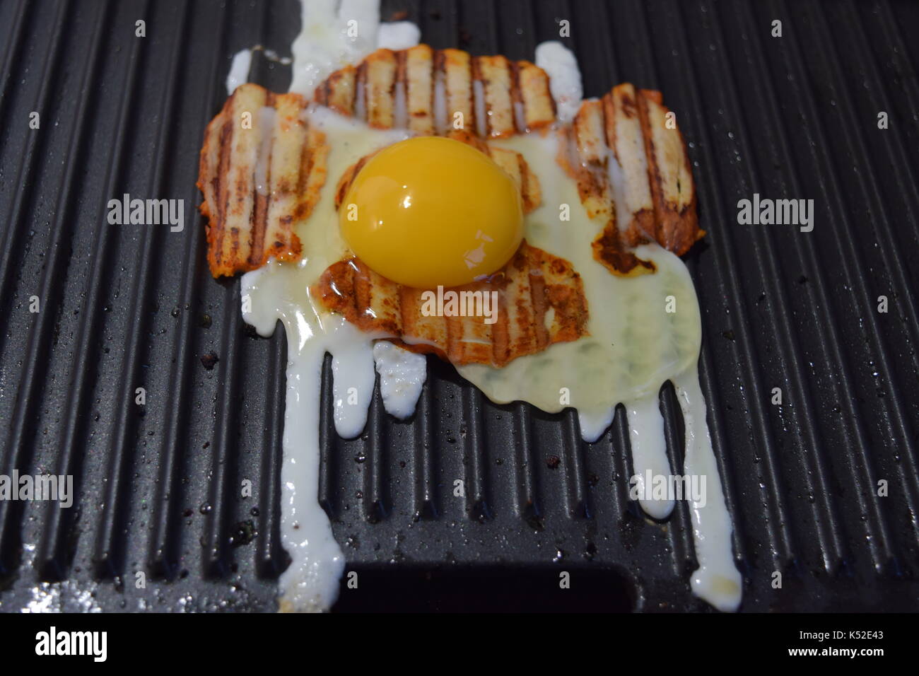 Egg and bacon cooking on a hot grill Stock Photo Alamy