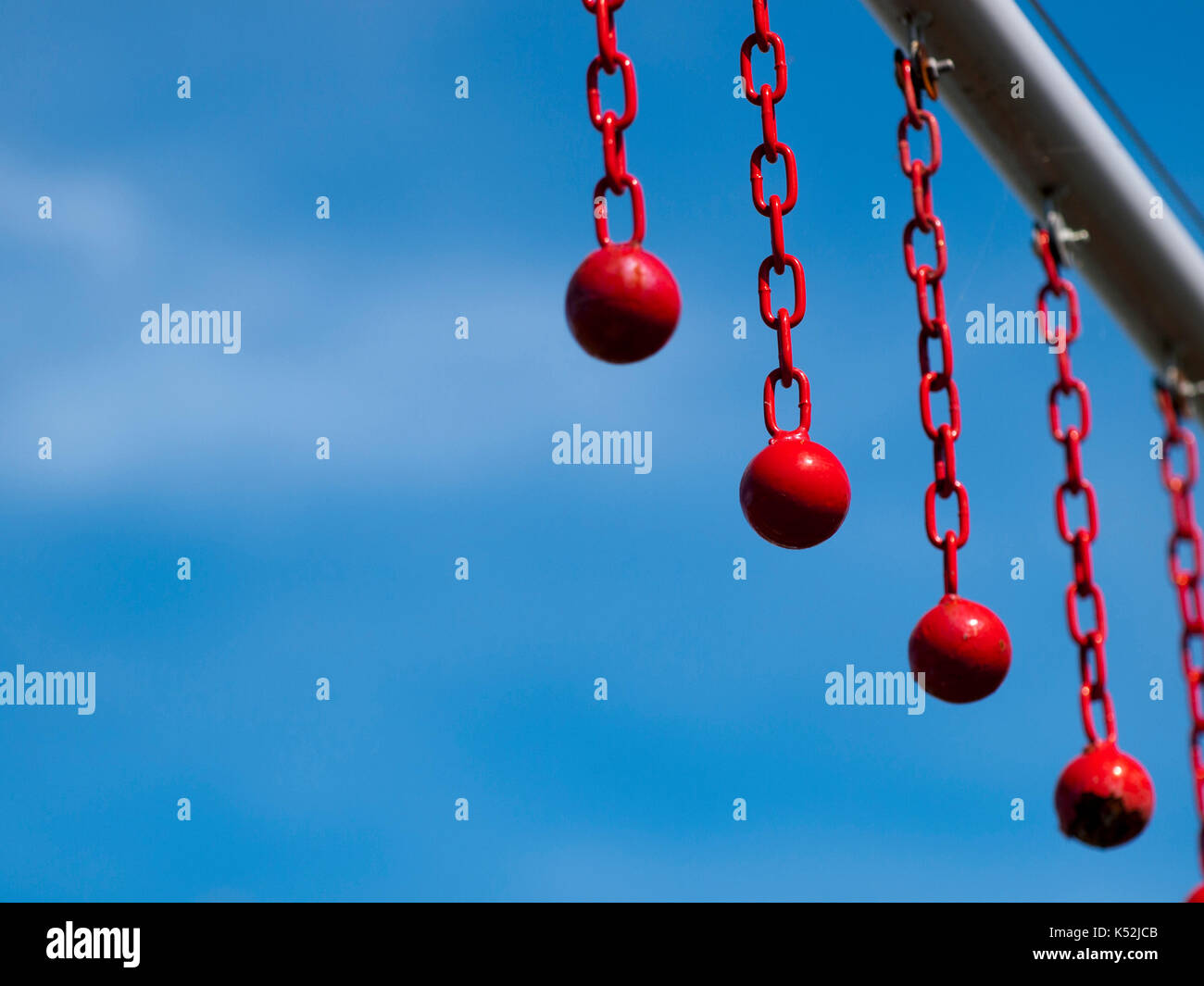 Red balls on chains hanging from a 'Maximum Height' bar, located above the entrance to a drive
