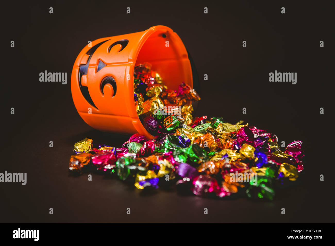 High angle view of bucket with chocolates during Halloween over black background Stock Photo