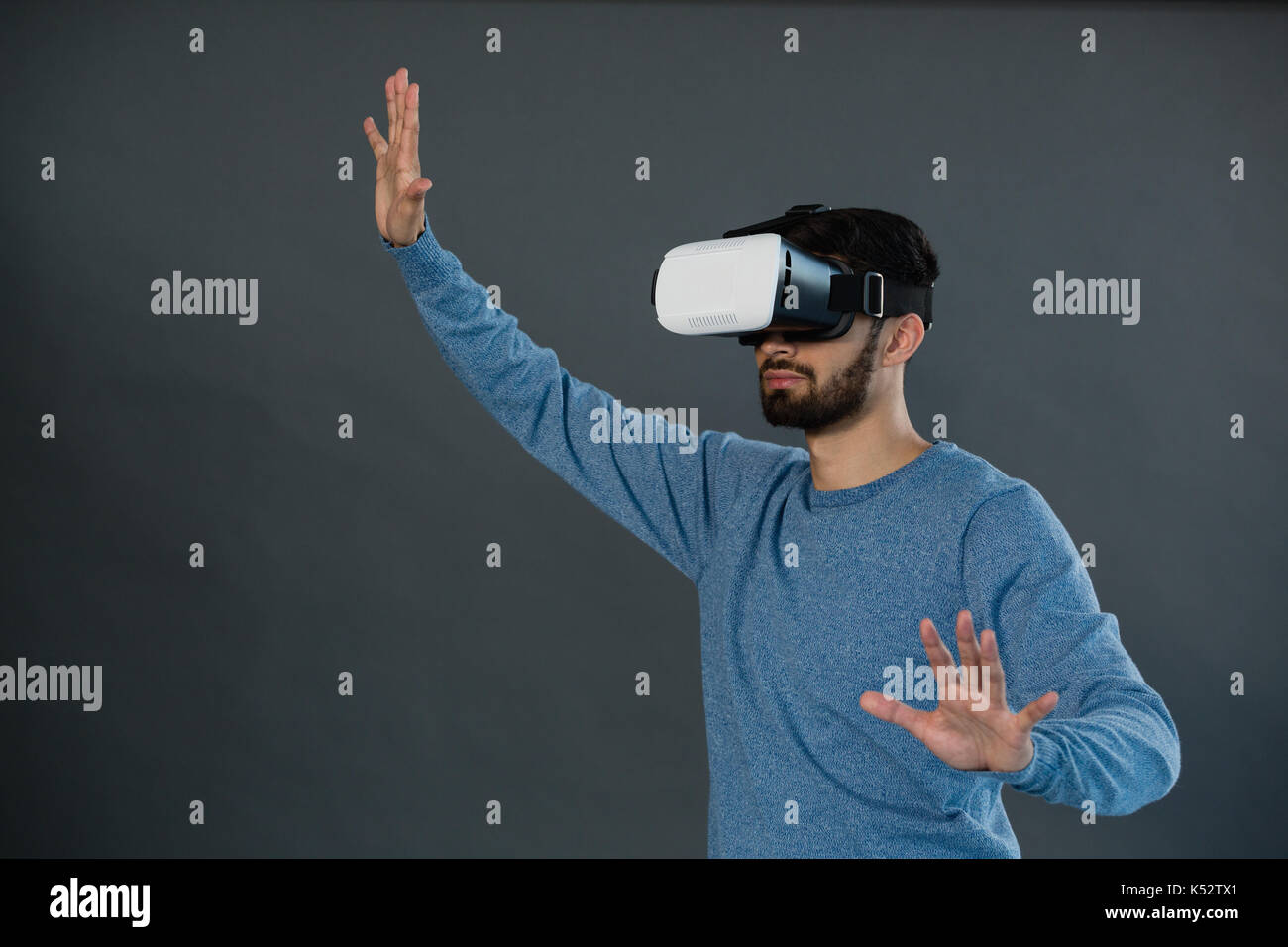 Man using virtual reality headset against grey background Stock Photo ...