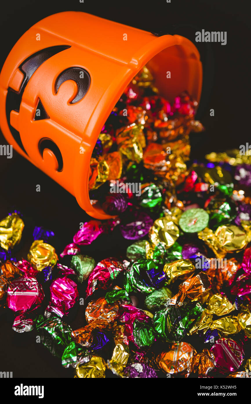 High angle view of orange bucket with chocolates over black background Stock Photo