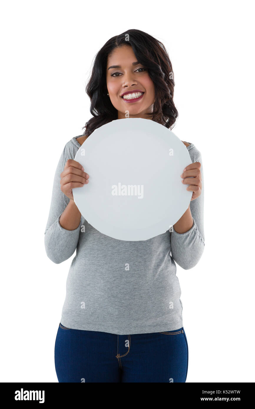 Portrait of smiling young woman holding circle shaped placard against white background Stock Photo