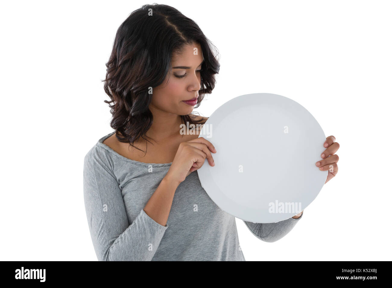 Young woman holding circle shaped placard over white background Stock Photo
