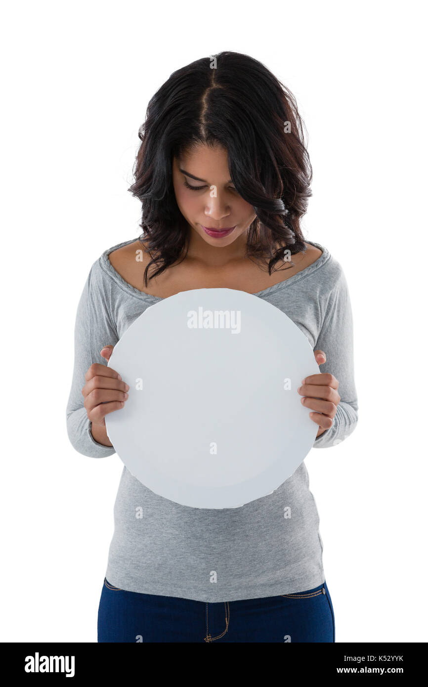 Young woman holding circle shaped placard against white background Stock Photo