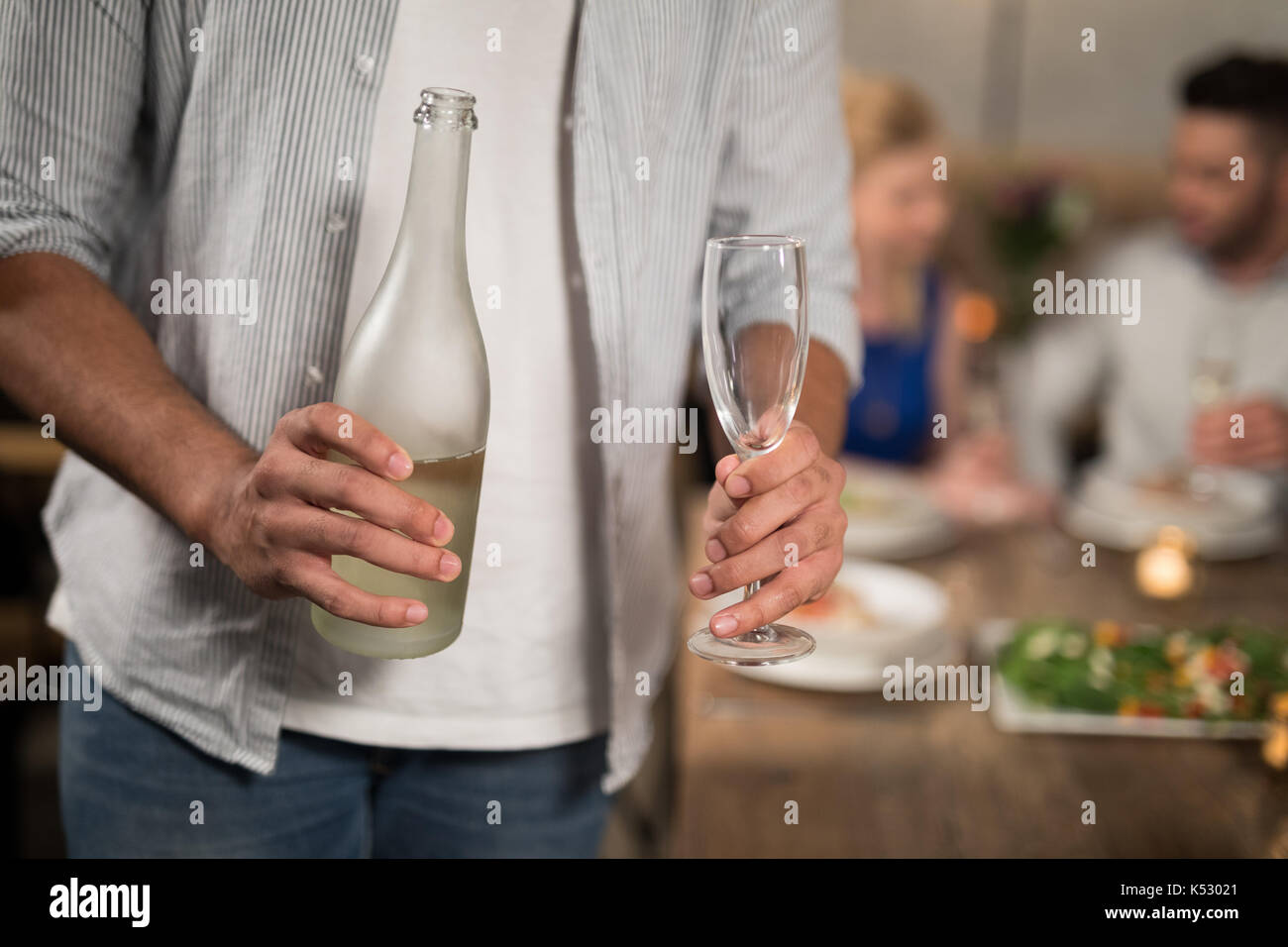 Mid section of man holding champagne in restaurant Stock Photo