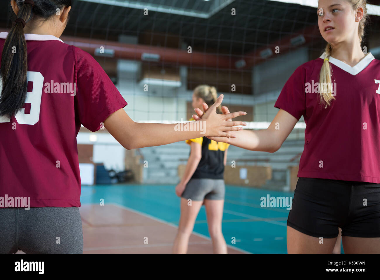 Two female players shaking hands with each other in the volleyball