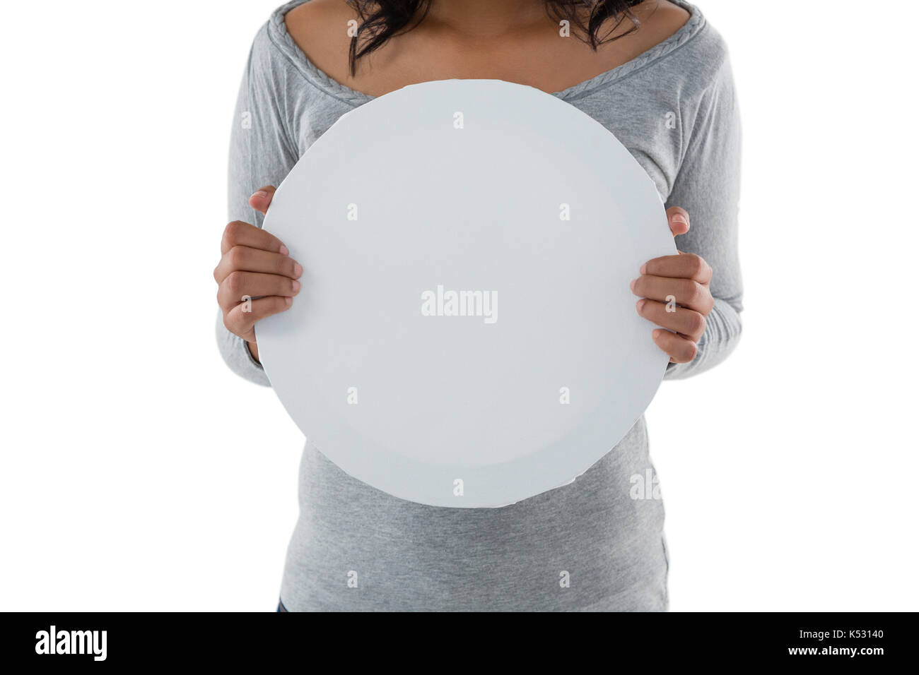 Mid section of woman holding circle shaped placard against white background Stock Photo
