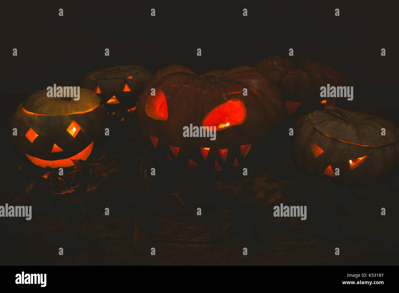 Illuminated jack o lanterns in darkroom during Halloween Stock Photo ...