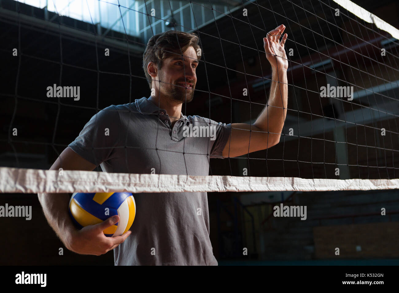 Male player with volleyball looking away at court Stock Photo