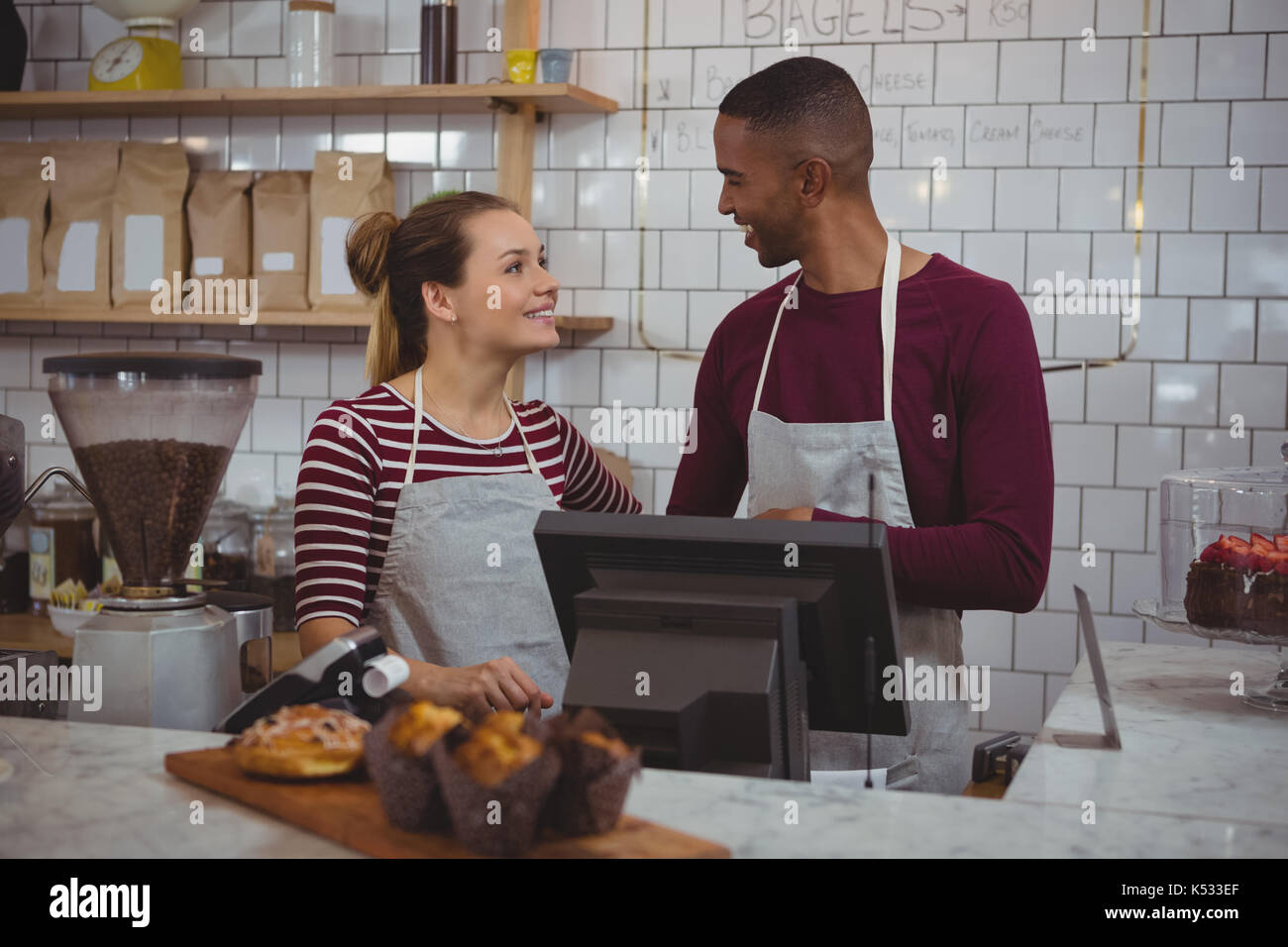 Young owners talking to each other while standing in cafe Stock Photo