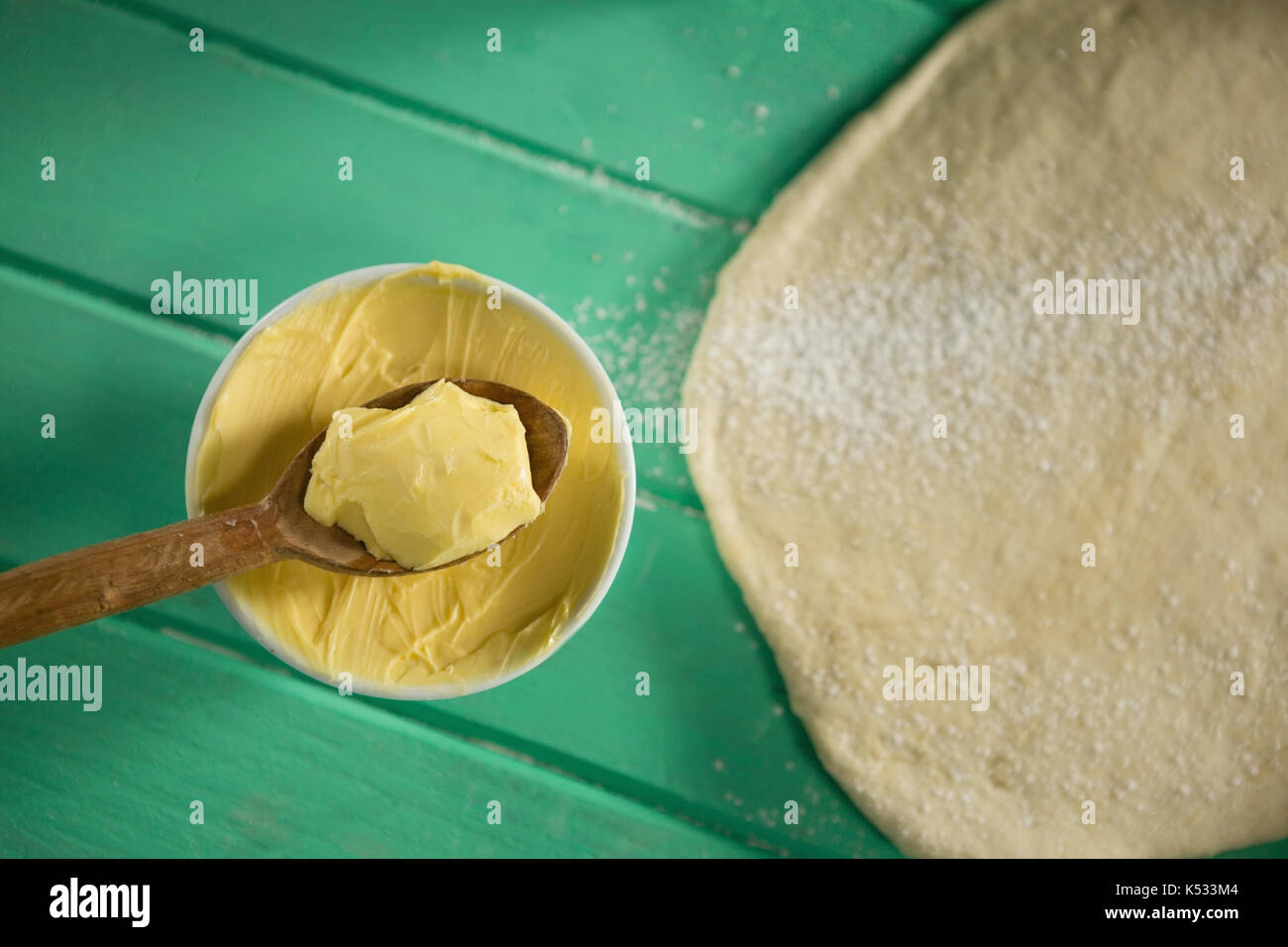 Overhead view of butter in bowl by rolled dough on table Stock Photo