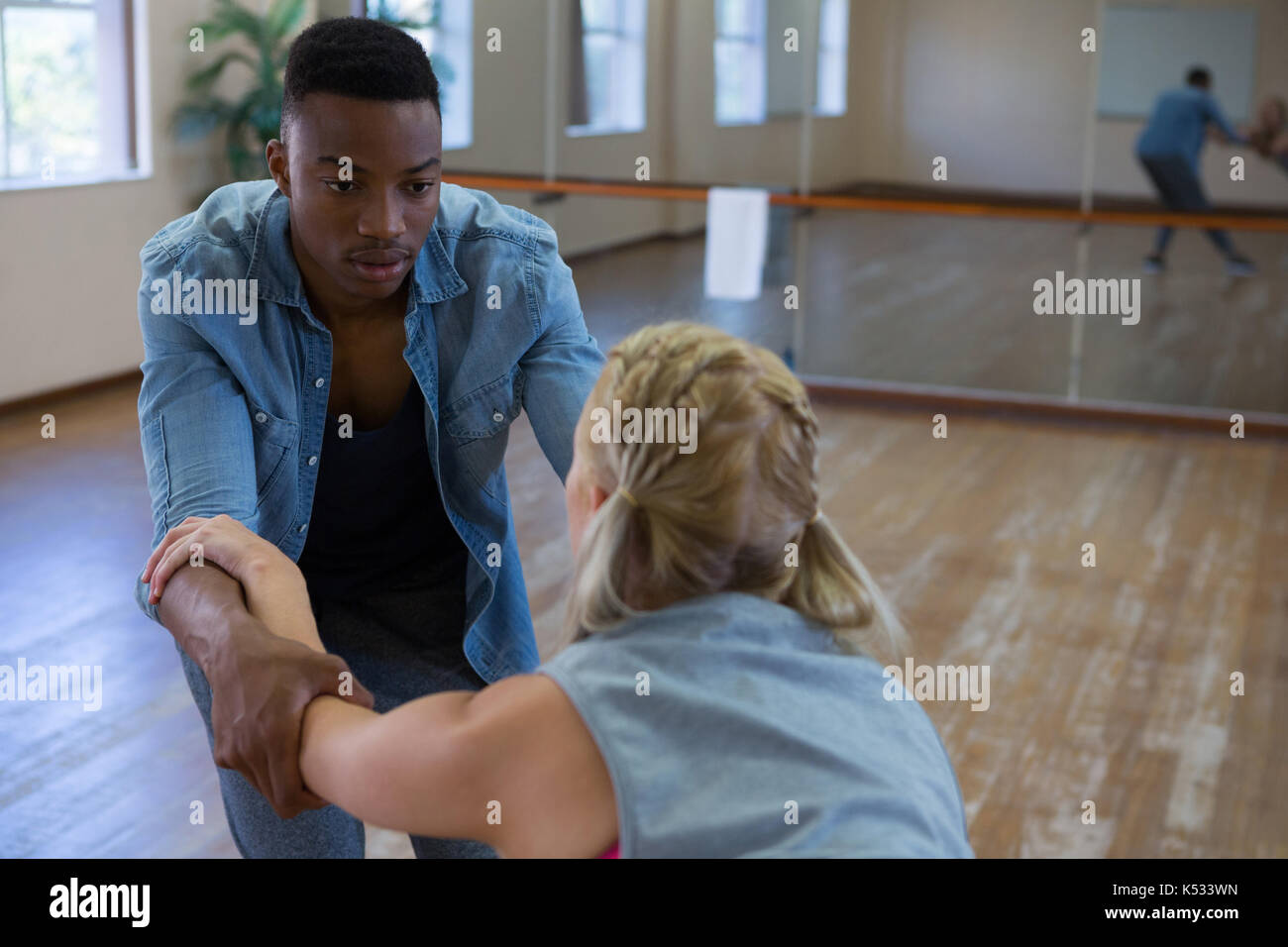 Young man looking at friend while dancing in studio Stock Photo