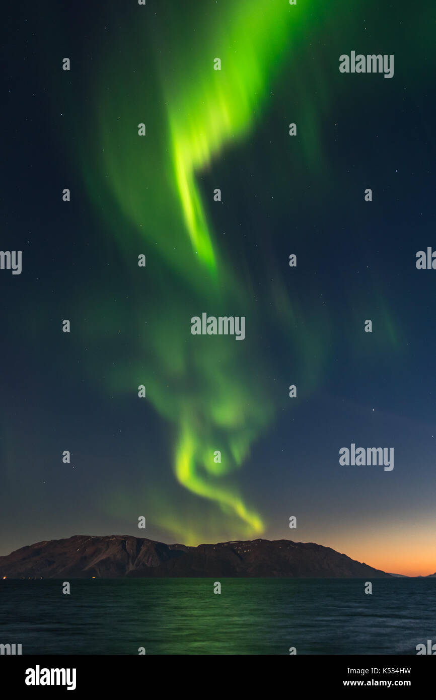 Northern lights, aurora borealis, above high mountains out in Alta fjord, Finnmark, Norway Stock Photo