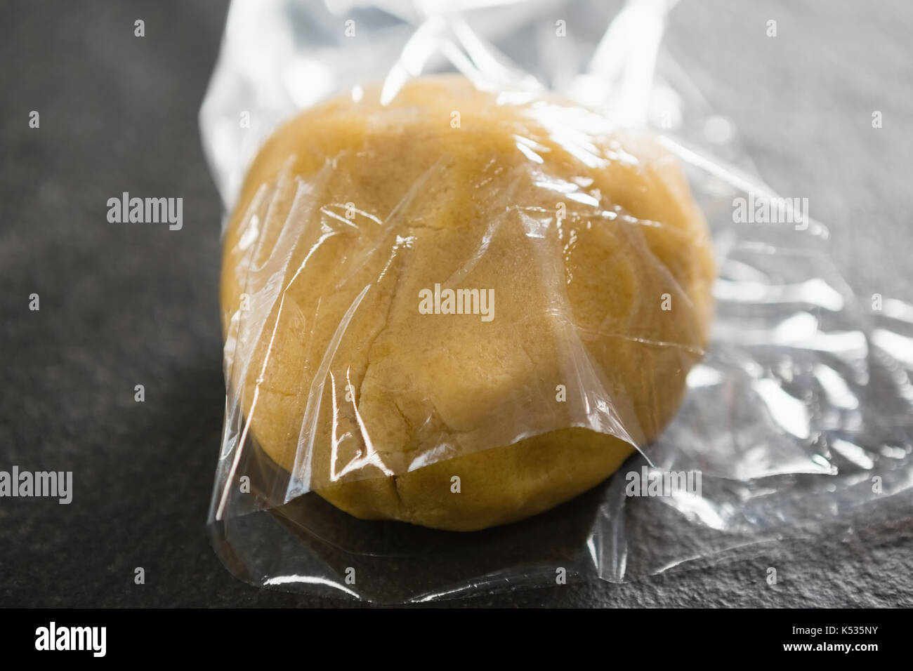 Close up of dough in plastic wrap on table Stock Photo Alamy