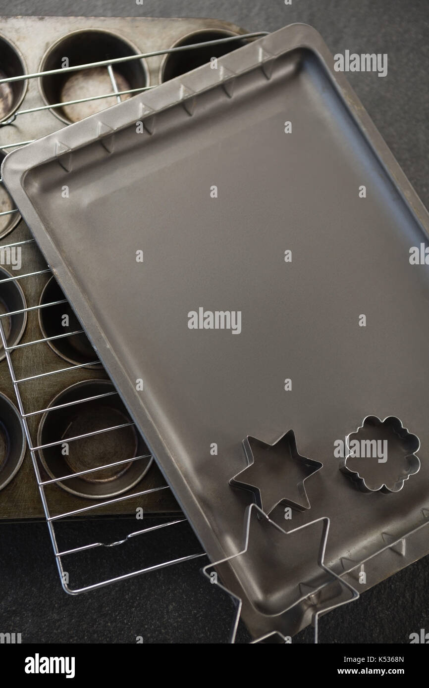 Various pastry cutter and baking sheet with cooling rack on muffin tin at table Stock Photo Alamy