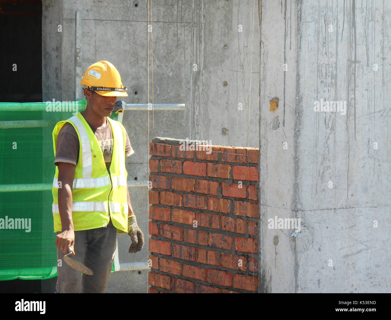 SELANGOR, MALAYSIA JANUARY 15, 2017 Bricklayer lay clay bricks block