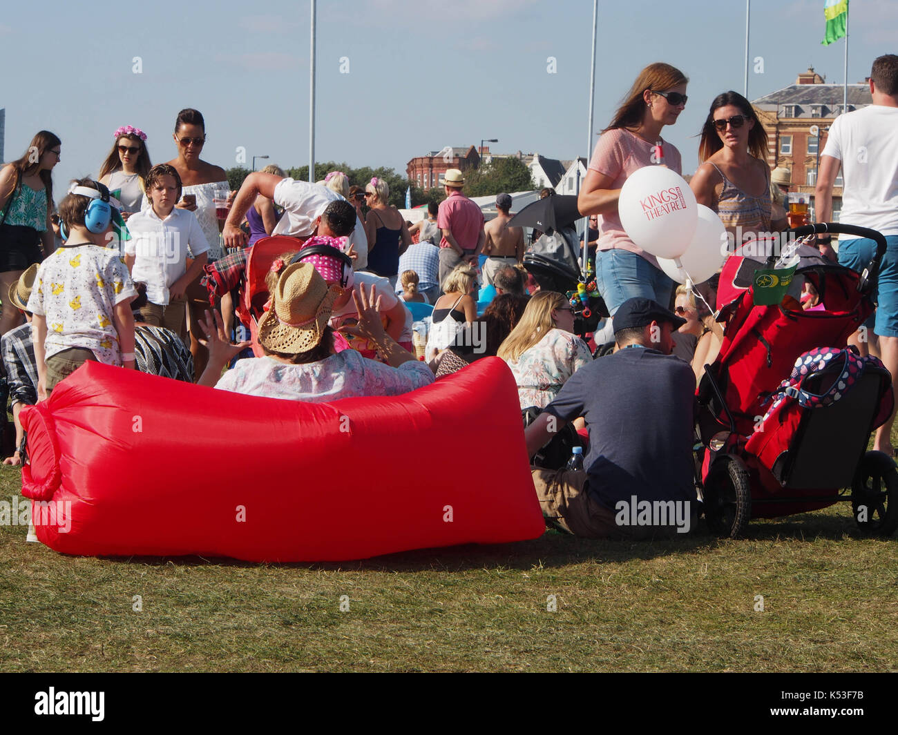 people sitting on an inflatable air bag at an outdoor festival Stock Photo
