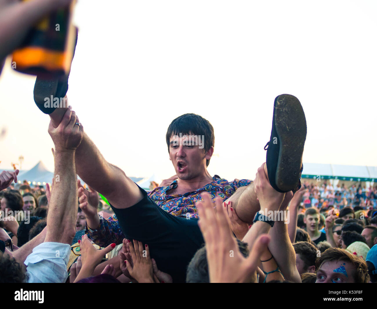 A young man crowd surfs over the audience at the Victorious music festival in Portsmouth, England Stock Photo